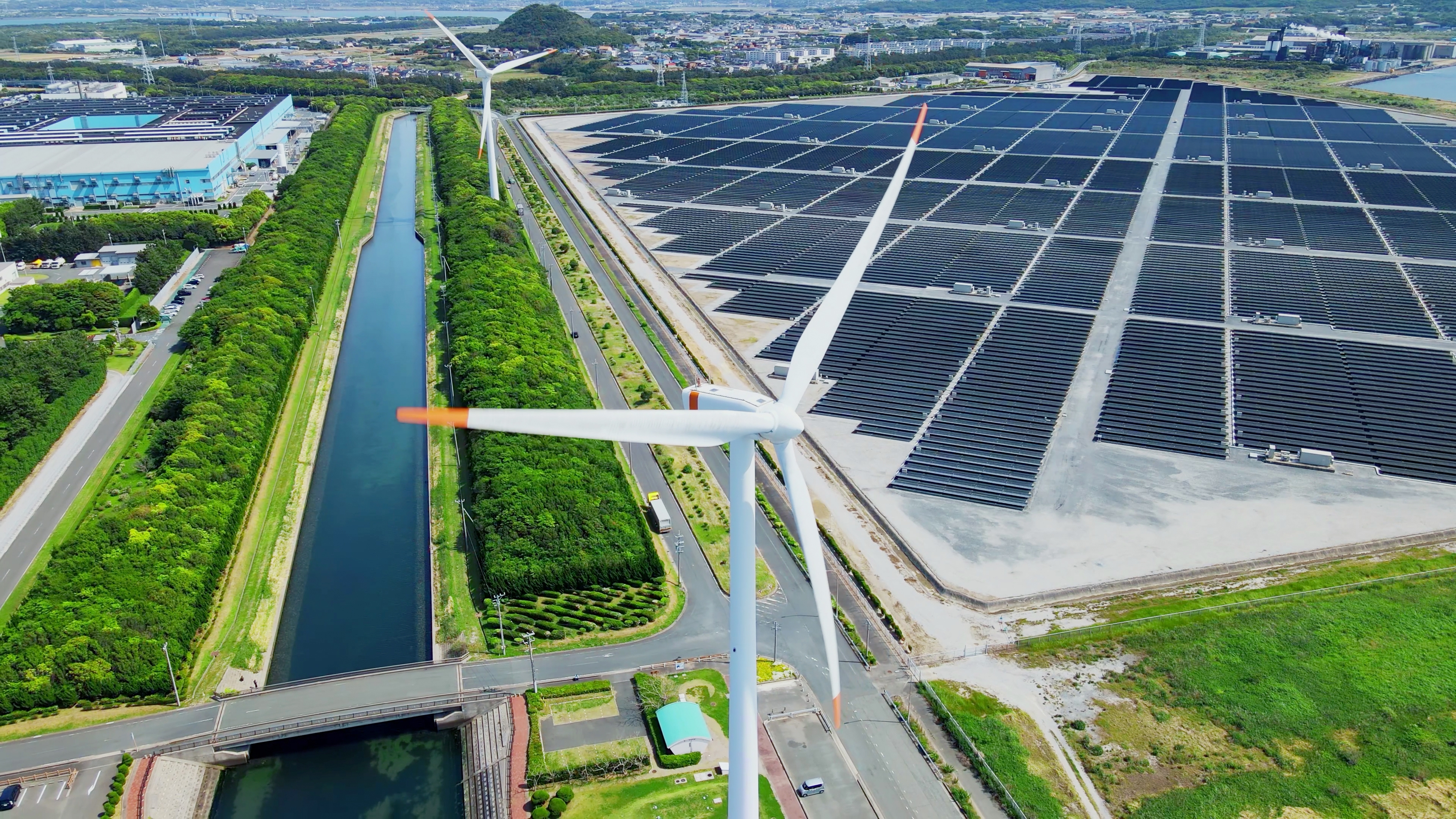 An aerial shot of a solar and wind farm with a river 